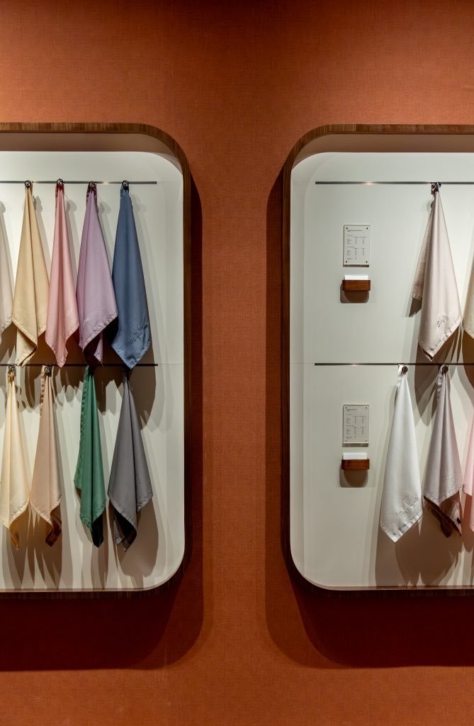 Rounded fabric displays set into a terracotta gallery wall