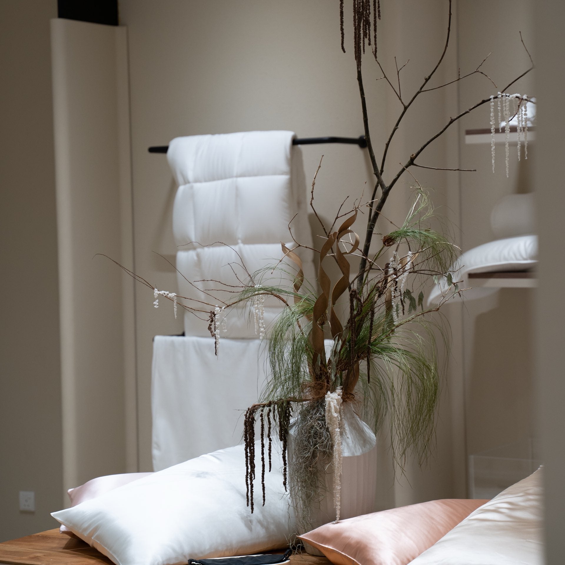 A relaxed pillow display with a loose natural branch arrangement