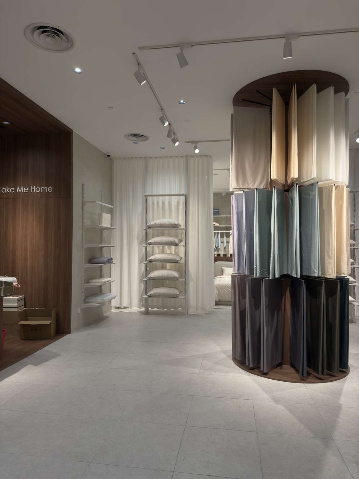 A drum of fabric samples on the shop floor, with open shelving beyond