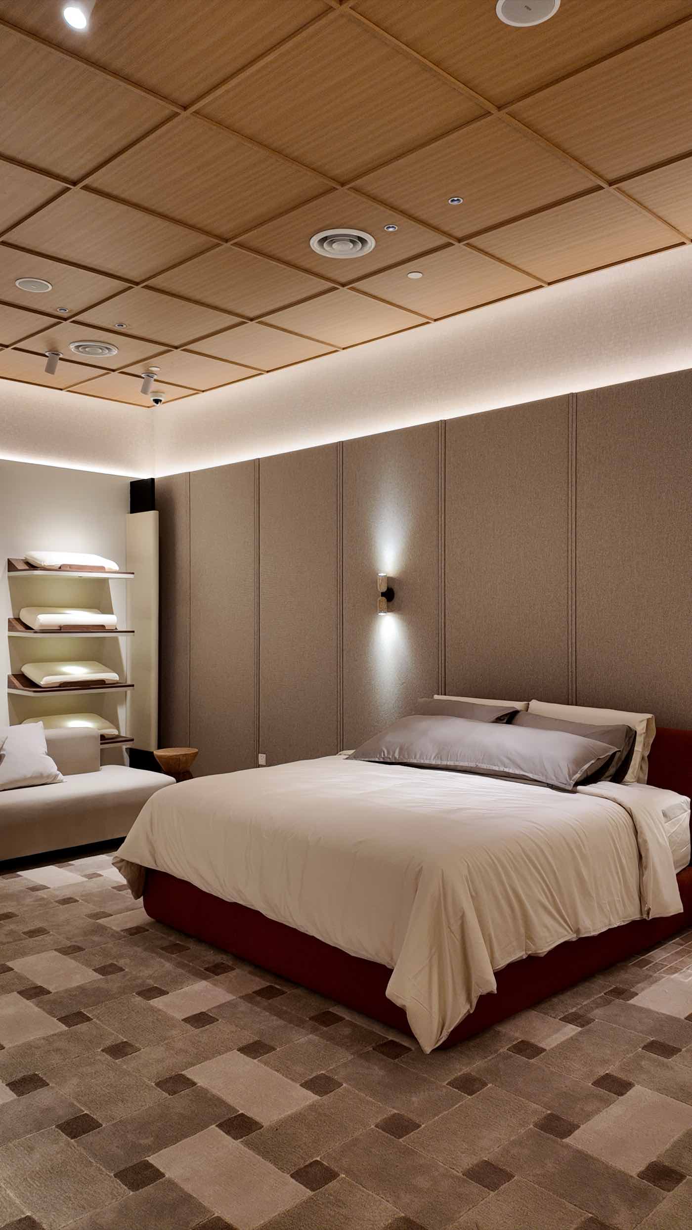 A dressed bed with a red upholstered base