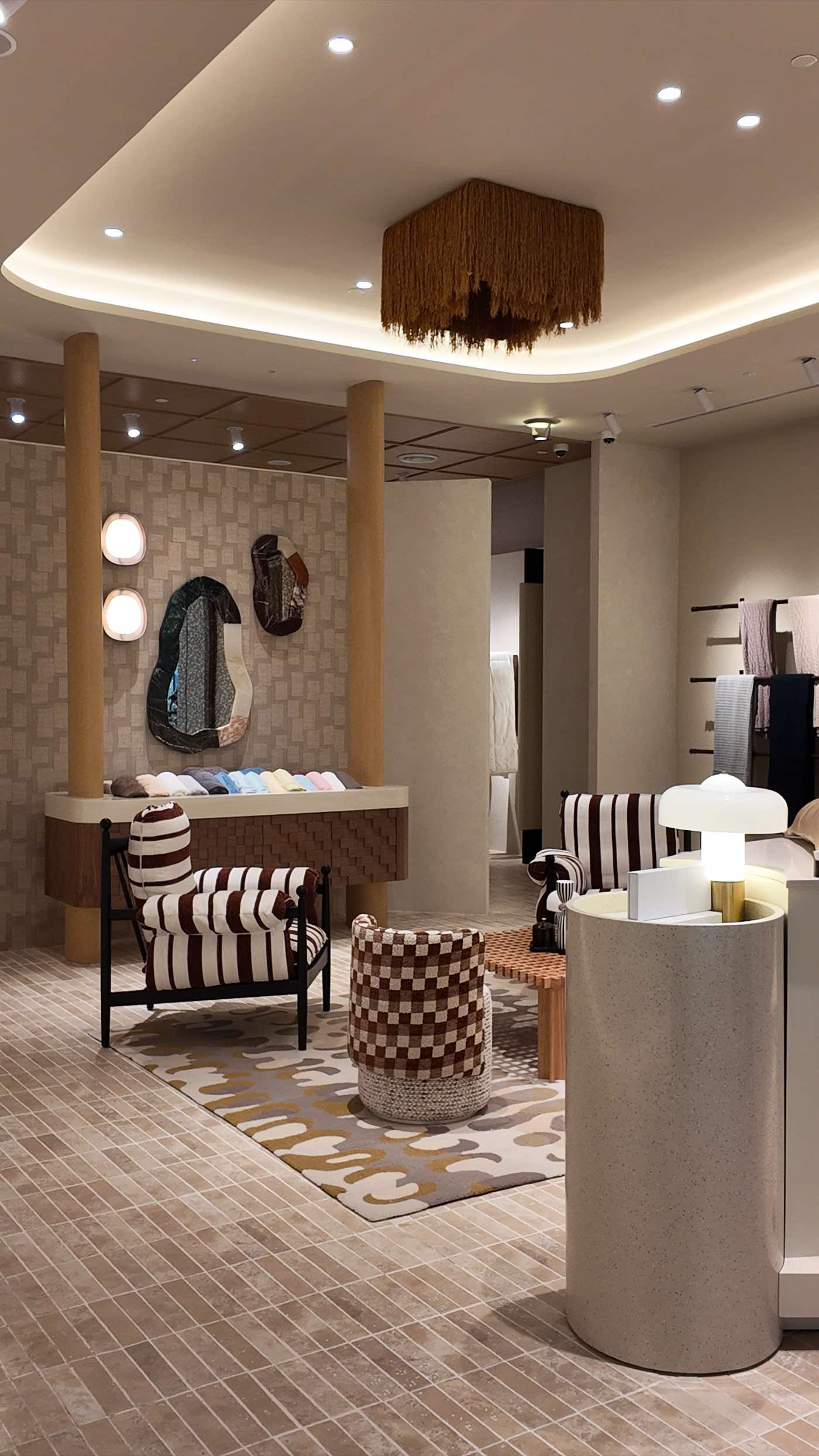 The lounge beneath a fringed pendant, with towels on the wall beyond